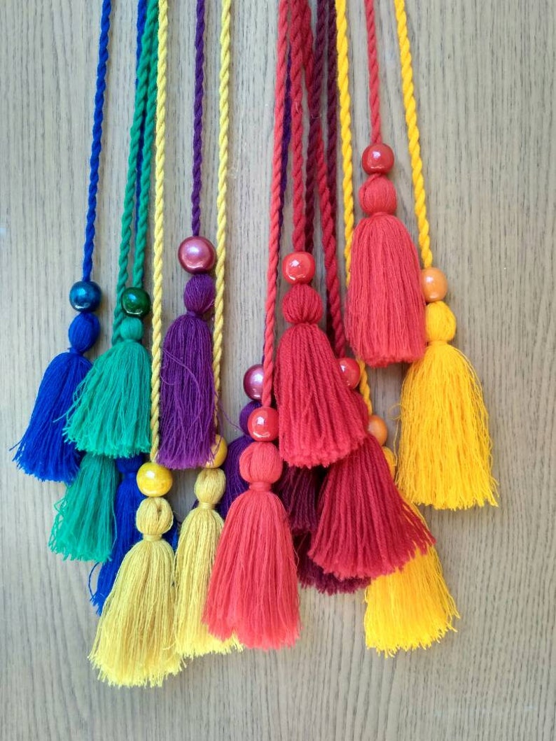 May include: A set of colorful tassel cords with wooden beads. The cords are in shades of blue, green, purple, red, and yellow.