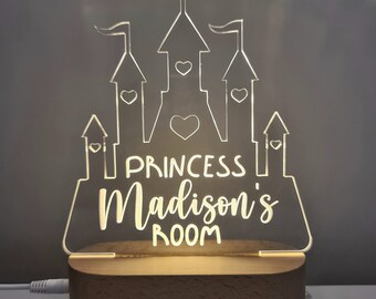 Puede incluir: Una luz nocturna de castillo de acrílico blanco con el texto "Princess Madison's Room" sobre una base de madera.