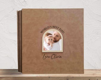 May include: A brown photo album with the text "WORLD'S BEST DAD" above a photo of a father and baby. The album also has the text "Love Olivia" and "Text Design 4".