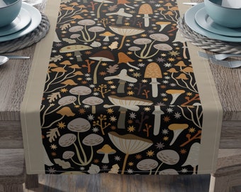 May include: A black table runner with a beige border features a repeating pattern of colorful mushrooms and stars. The runner measures 16 inches by 72 inches.