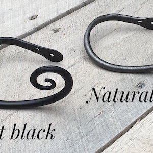 May include: Two metal curtain tiebacks with a spiral design. One is flat black and the other is natural iron.
