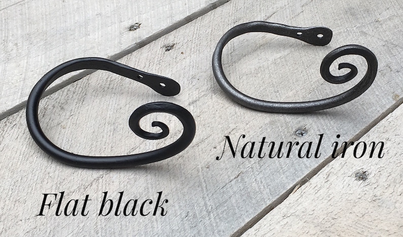 May include: Two metal curtain tiebacks with a spiral design. One is flat black and the other is natural iron.