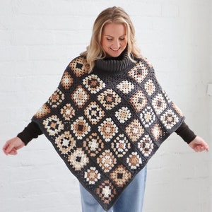May include: A brown, white, and beige crochet poncho with a turtleneck collar. The poncho is made of granny squares and is worn by a person with blonde hair.
