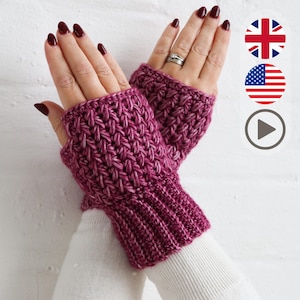 Può includere: Un paio di guanti senza dita lavorati a mano in una tonalità magenta intenso. I guanti presentano un motivo a trama strutturata e polsini a coste. L'immagine mostra i guanti indossati, evidenziando il loro design e colore. Un accessorio accogliente.