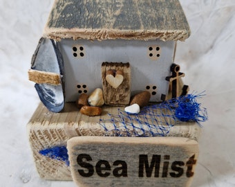 Sea mist. driftwood fishing cottage by the sea,in grey with muscle shell boat.