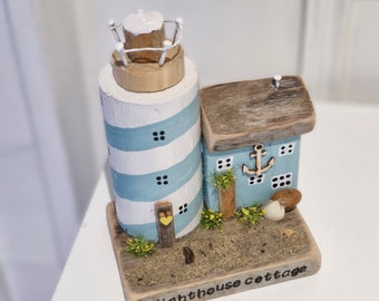 Lighthouse cottages. Pretty blue cottage and lighthouse coastal scene
