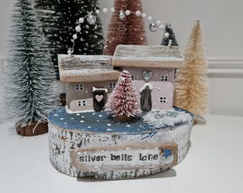 Silver bell lane. Pastel cottages set on rustic log slice,seaglass ponds,hand stamped sign,snowball and silver bell garland above roofs