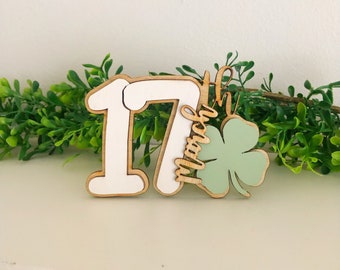 May include: Wooden cutout of the number 17 with the word "March" and a green shamrock.