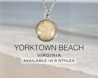 May include: A silver-toned necklace with a round pendant. The pendant contains sand from Yorktown Beach, Virginia. The text "YORKTOWN BEACH VIRGINIA AVAILABLE IN 8 STYLES" is displayed below the necklace.