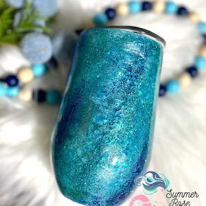 May include: A teal and blue glitter tumbler with a black lid. The tumbler has a shiny, textured surface with a gradient effect. The Summer Rose Shoppe logo is visible in the bottom right corner.