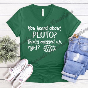 May include: A green v-neck t-shirt with the text "You heard about Pluto? That's messed up, right?" in white. A pineapple graphic is below the text.