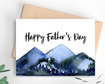 May include: A white card with the text "Happy Father's Day" in black lettering. The card features a watercolor illustration of blue mountains with green trees in the foreground.