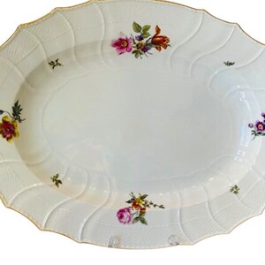 May include: A white oval serving platter with a raised, textured rim and a gold trim. The platter is decorated with hand-painted floral designs in shades of pink, yellow, orange, and purple.