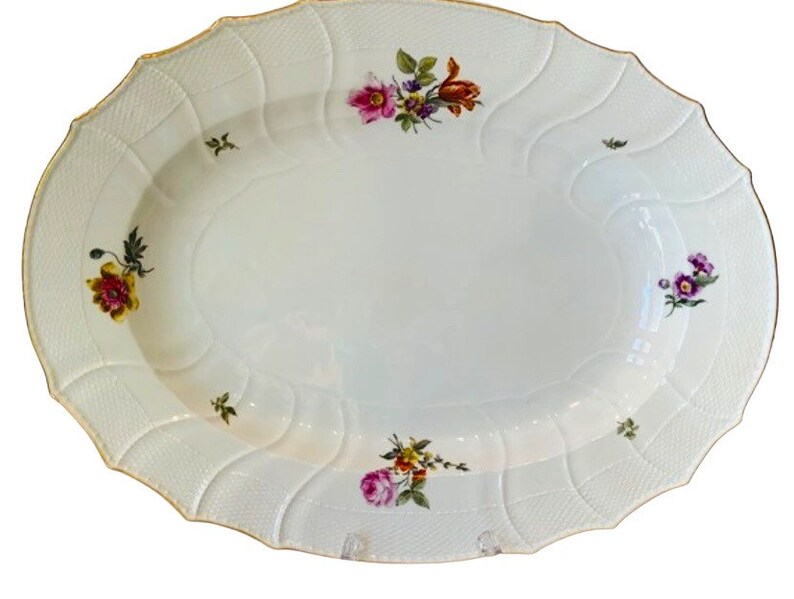 May include: A white oval serving platter with a raised, textured rim and a gold trim. The platter is decorated with hand-painted floral designs in shades of pink, yellow, orange, and purple.