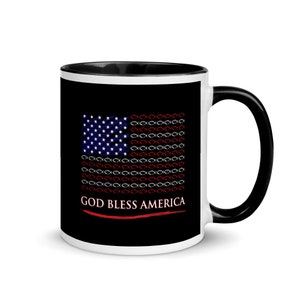 Op de afbeelding: Een zwart-witte koffiemok met een patriottisch ontwerp. De mok heeft een gestileerde Amerikaanse vlag met vissymbolen in plaats van strepen en de tekst "GOD BLESS AMERICA". De handgreep en de binnenkant zijn zwart.