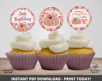 May include: Three printable cupcake toppers featuring a pumpkin, fall leaves, and the text "First Birthday" and "Our little pumpkin is turning one".