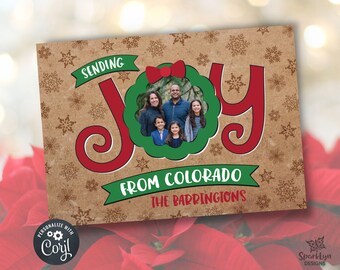 May include: A Christmas card with a red, green, and white "Joy" design. A family photo is in a wreath-shaped frame. The text "Sending Joy from Colorado The Barringtons" is on the card.