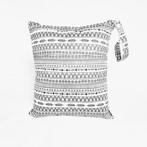 May include: A white and black patterned bag with a handle. The bag features a repeating design of arrows, circles, and arches. The handle is also decorated with the same pattern. The bag is made of a soft material.