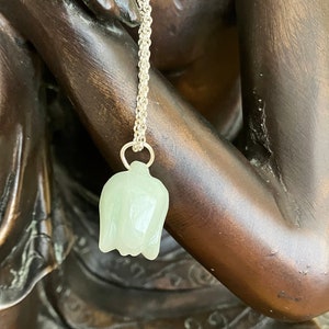 Könnte beinhalten: Eine silberne Kettenkette mit einem hellgrünen Jade-Blumenanhänger.