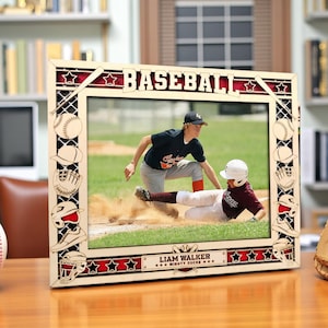 May include: Wooden baseball-themed picture frame with the word "BASEBALL" at the top. The frame features baseball-related cutouts and a photo of two baseball players on a field. The name "LIAM WALKER" is displayed at the bottom.