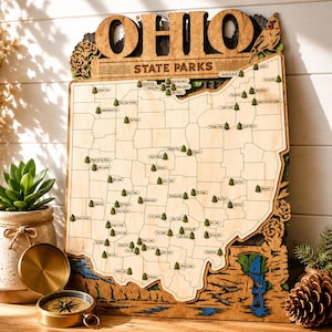 May include: A wooden wall map of Ohio State Parks featuring laser-cut state borders, engraved park names, and small green tree icons marking locations. The top header reads OHIO STATE PARKS, and the design includes decorative wood carvings.