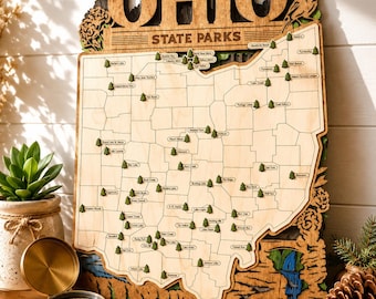 May include: A wooden wall map of Ohio State Parks featuring laser-cut state borders, engraved park names, and small green tree icons marking locations. The top displays the text OHIO STATE PARKS with a cardinal bird and floral accents.