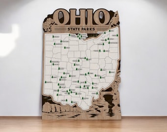 Puede incluir: Un mapa de madera de Ohio con el texto "Ohio State Parks" y el contorno del estado lleno de pequeños árboles verdes que representan los parques estatales.