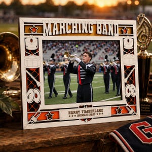 May include: A rectangular wooden picture frame featuring the text MARCHING BAND at the top and HARRY TIMBERLAKE GREENOAKS EAGLES at the bottom. The frame is decorated with laser-cut icons of drums, cymbals, and trumpets, surrounding a photo of a band.