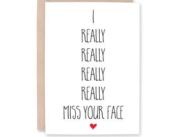 Könnte beinhalten: Eine weiße Karte mit schwarzem Text, der "I really really really really miss your face" lautet, mit einem kleinen roten Herzen unten.