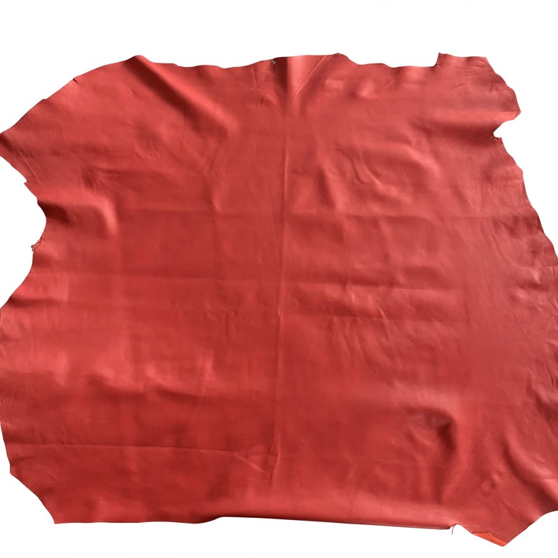 May include: A large piece of red leather. The leather is smooth and has a slight sheen.