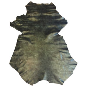 May include: A piece of metallic-looking leather with a textured, scale-like pattern. The leather has a dark, iridescent sheen with hints of gold and blue. The edges are uneven, indicating it's a natural hide, suitable for crafting.
