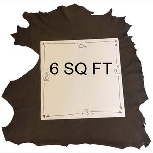 May include: A dark brown leather hide with a white square overlay. The overlay indicates the dimensions are 18 inches by 18 inches, with the text "6 SQ FT". The leather has a rough, uneven edge.