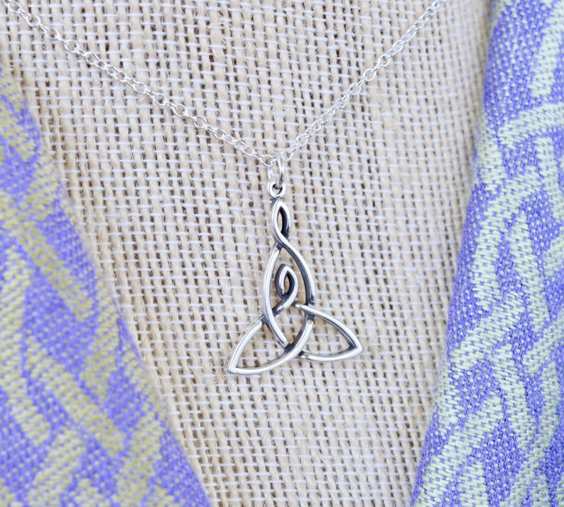 May include: A silver necklace with a Celtic knot pendant. The pendant is in the shape of a trinity knot, which is a symbol of love, faith, and hope.