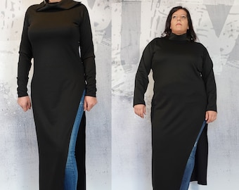 May include: A long black mock neck shirt with a side slit and long sleeves. The shirt is worn with blue jeans and black ankle boots.