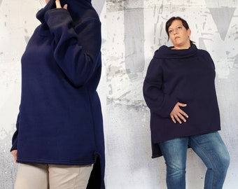 May include: A navy blue oversized sweater with a cowl neck and side slits. The sweater is shown on two models, one wearing beige pants and the other wearing blue jeans.