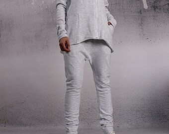 May include: A grey zip-up jacket with a large collar and matching grey sweatpants. The jacket has a zipper closure and a pocket on the left side. The sweatpants have a loose fit and a cuffed hem.