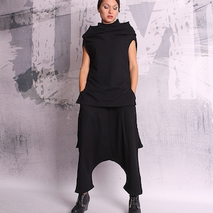 May include: A black, high-waisted, wide-leg pants with a loose, flowing fit. The pants have a unique, draped design and a relaxed, comfortable look.