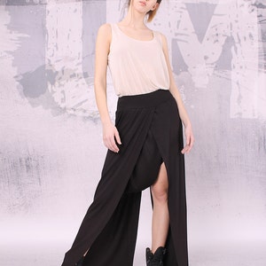 May include: A black maxi skirt with a high waist and a long, flowing design. The skirt has a slit on the front and a wrap-around style. The skirt is made of a soft, comfortable fabric.