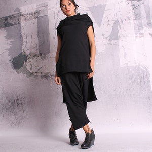 May include: A black sleeveless top with a cowl neck and a long, flowing skirt. The outfit is made of a soft, drapey fabric and has a relaxed, comfortable fit.