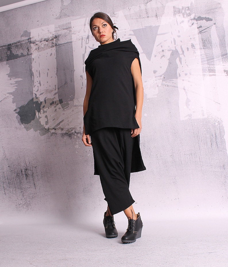 May include: A black sleeveless top with a cowl neck and a long, flowing skirt. The outfit is made of a soft, drapey fabric and has a relaxed, comfortable fit.