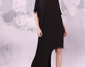 May include: A black maxi dress with a high-low hemline. The dress has a relaxed fit and a scoop neckline. The model is wearing the dress with brown ankle boots.