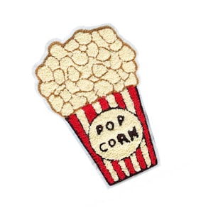 May include: A red and white striped popcorn bucket with the word "POP CORN" printed on it. The bucket is filled with white popcorn.