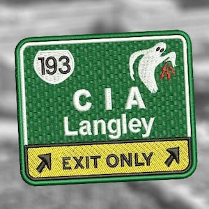 May include: A green and yellow highway sign with the text "CIA Langley" and "Exit Only" with an arrow pointing right. The sign also has a white ghost holding a red object and the number "193" in a white circle.