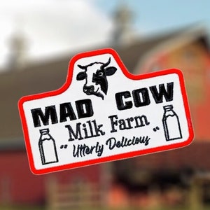 Puede incluir: Parche blanco y rojo con una cabeza de vaca negra y el texto "MAD COW Milk Farm "Utterly Delicious" ".