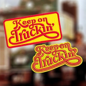 Puede incluir: Dos parches bordados amarillos y rojos con el texto "Keep on Truckin'" en un estilo de fuente retro.