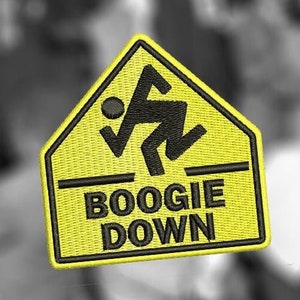 May include: Yellow warning sign with a black stick figure dancing and the text "BOOGIE DOWN" in black.