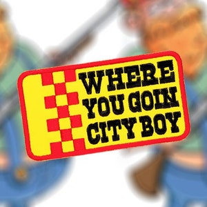 Puede incluir: Un parche amarillo y rojo con el texto "WHERE YOU GOIN CITY BOY" en letras negras. El parche tiene un patrón de cuadros en la esquina superior izquierda.