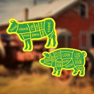 Puede incluir: Dos parches verdes y amarillos que representan los cortes de carne de una vaca y un cerdo. El parche de vaca muestra la cabeza, el chuck, la placa de la pierna, la costilla, el lomo, el flanco, el solomillo y el redondo. El parche de cerdo muestra la cabeza, la papada, el cuello, la nalga, el lomo, el jamón de picnic, las costillas, el tocino, la pierna y la pata.