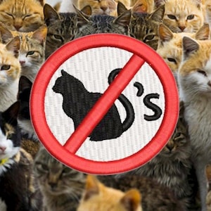 Puede incluir: Un círculo rojo y blanco con una línea roja diagonal que lo atraviesa. El círculo tiene un fondo blanco con una silueta negra de un gato dentro. El texto "Cat's" está escrito en negro sobre el fondo blanco. El círculo está rodeado de un grupo de gatos de varios colores y patrones.