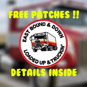 May include: A red, white, and black truck patch with the text "East Bound & Down Loaded Up & Truckin'" and a cartoon image of a semi-truck. The text "Free Patches!!" is above the patch and the text "Details Inside" is below the patch.